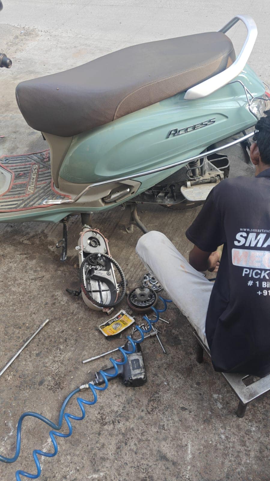 Smart Mechanik mechanic in uniform servicing a Honda Activa